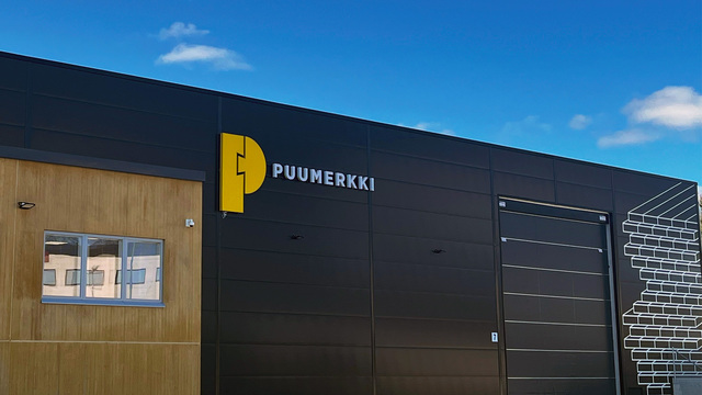 Puumerkin Vantaan toimipiste ulkoa päin: Puumerkin logo seinässä ja terminaalin ovi sekä toimiston ikkunat.